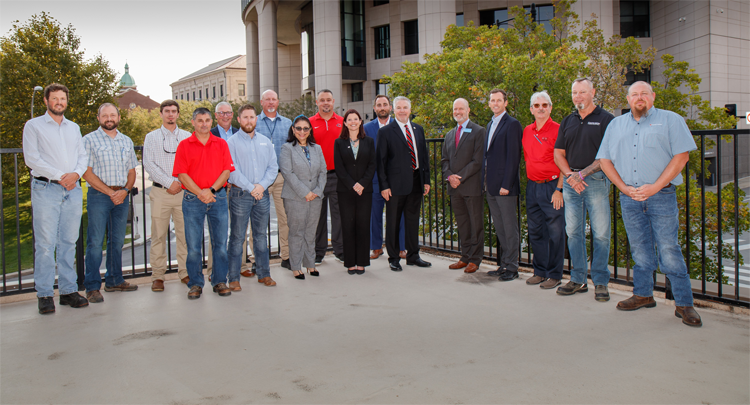 17 members of the Build Safe Partnership Program pose for a picture on Builders' 720 Oak street patio